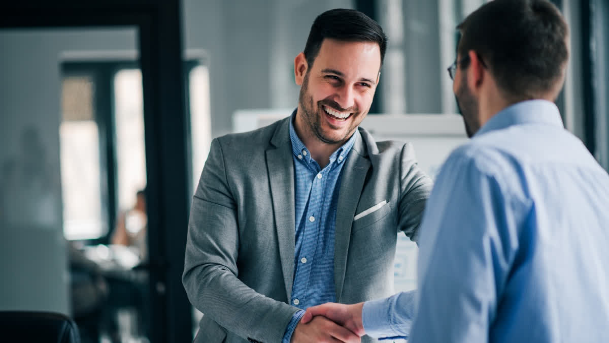 Don’t Just Survive Stress, Use It to Become a Better, Friendlier Version of Yourself Extroverted corporate executive shaking hands