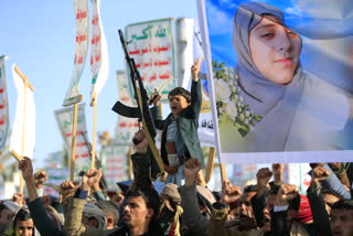 Supporters of the Houthi authorities brandish their weapons during a protest against Saudi intervention in Yemen, in Sanaa, on October 9.