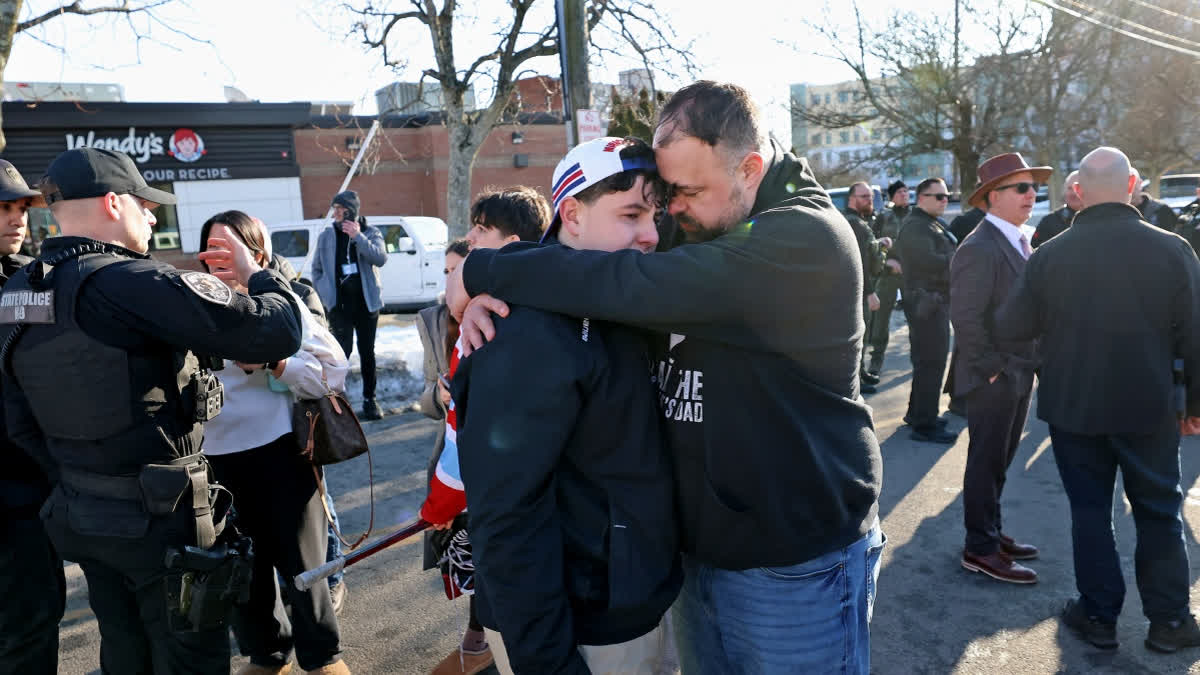 A father hugs his son outside of the Lynch Arena in Pawtucket, R.I., after a shooting at the ice rink, Monday, Feb. 16, 2026.
