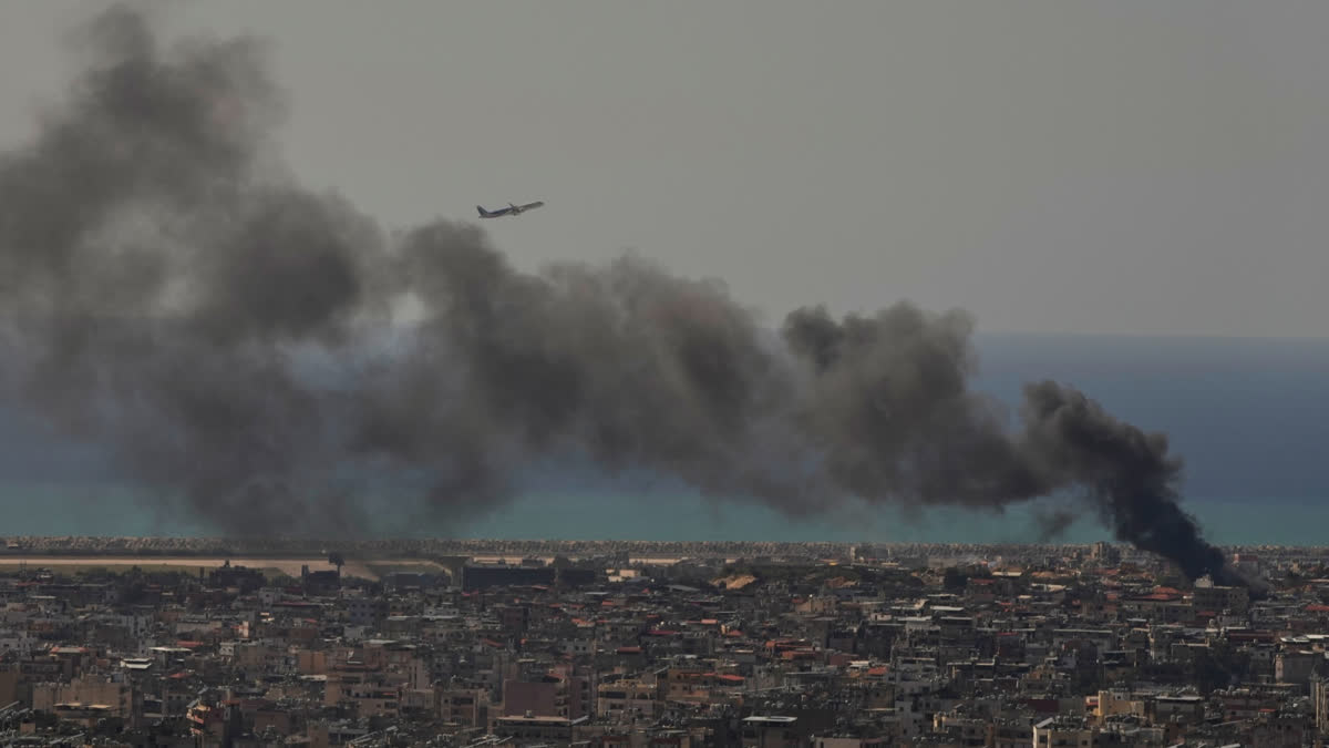 A Middle East Airlines plane takes off from Rafik Hariri International Airport as smoke rises from the site of an Israeli airstrike in Dahiyeh, Beirut's southern suburbs, Lebanon, Tuesday, March 17, 2026.