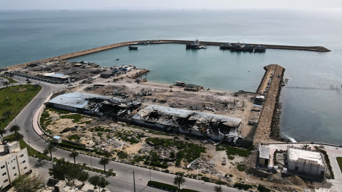 Backdropped by ships in the Strait of Hormuz, damage, according to local witnesses caused by several recent airstrikes during the U.S.-Israel military campaign, is seen on a fishing pier in the port of Qeshm island, Iran, Monday, April 13, 2026.
