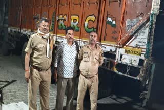 अवैध शराब से भरे ट्रक के साथ पुलिसकर्मी