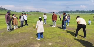 Tourists enjoy golf at the green golf course at Gulmarg