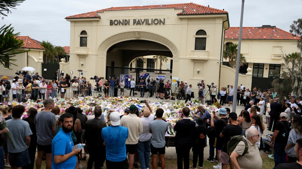 People gather at a floral tribute outside Bondi Pavilion at Bondi Beach on Tuesday, Dec. 16, 2025, following Sunday's shooting in Sydney, Australia.