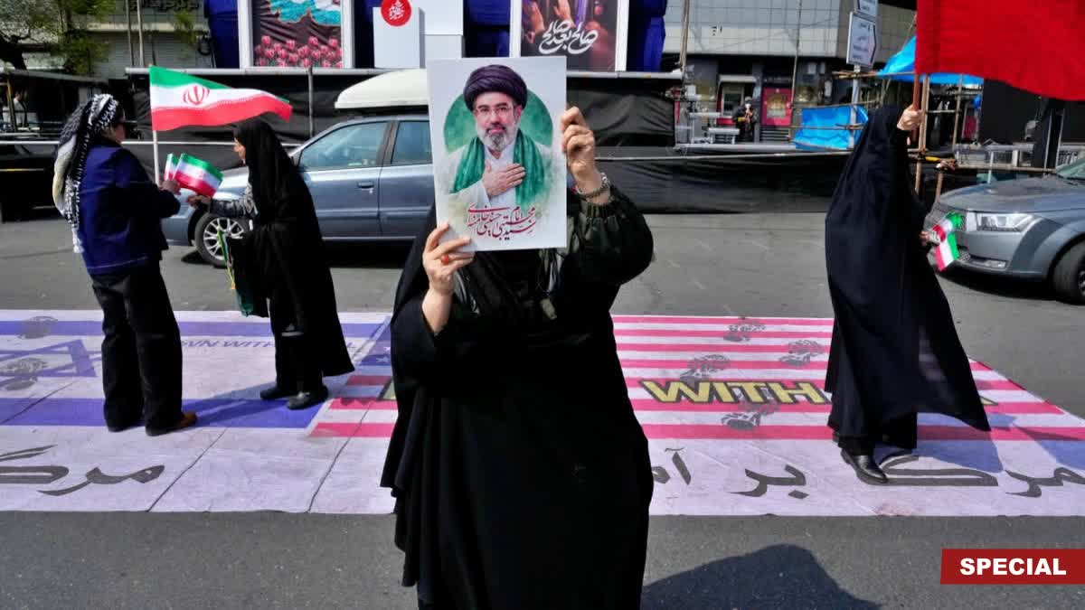 A woman displays a poster of the Iranian Supreme Leader Ayatollah Mojtaba Khamenei as she waves her country's flag during a campaign in support of the government at the Enqelab-e-Eslami, or Islamic Revolution, square in downtown Tehran, Iran, Saturday, March 14, 2026