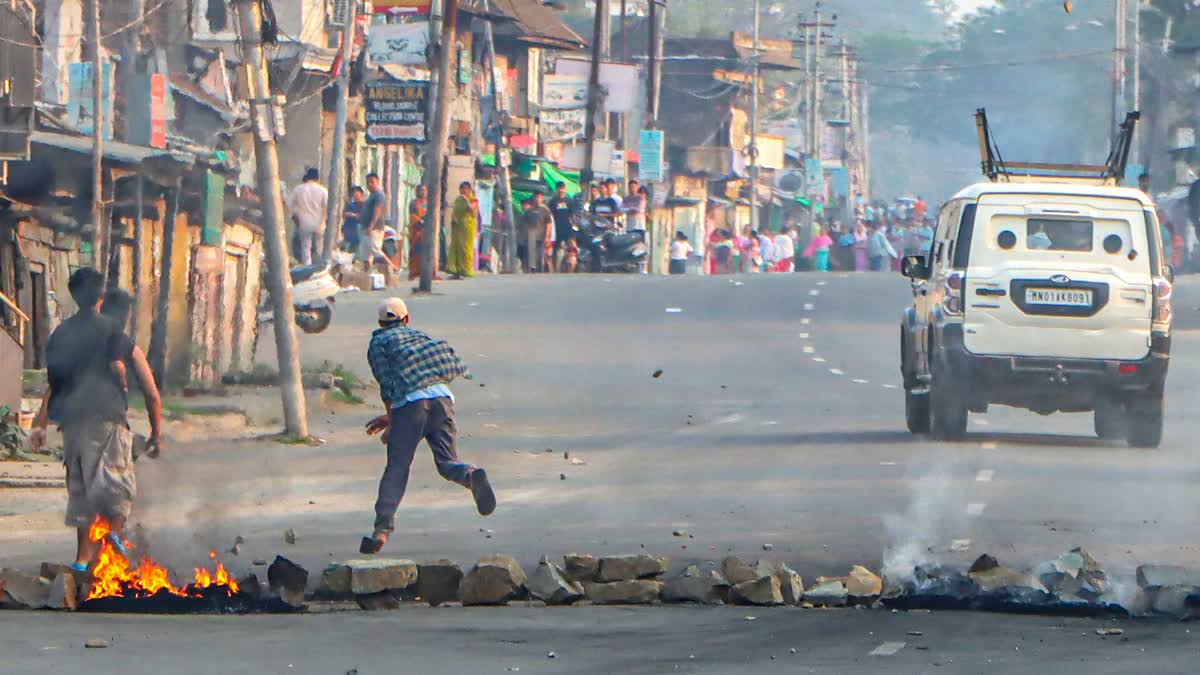 Protesters throw stones at a security forces vehicle passing through Thinungei during clashes in Bishnupur district on Tuesday, April 14, 2026.