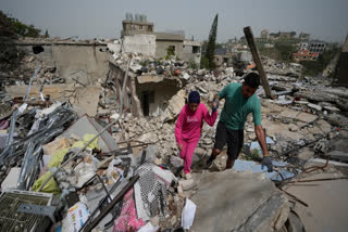 Residents walk on the rubble of destroyed houses on the second day of a ceasefire between Hezbollah and Israel in Jibchit village, south Lebanon, Saturday, April 18, 2026.