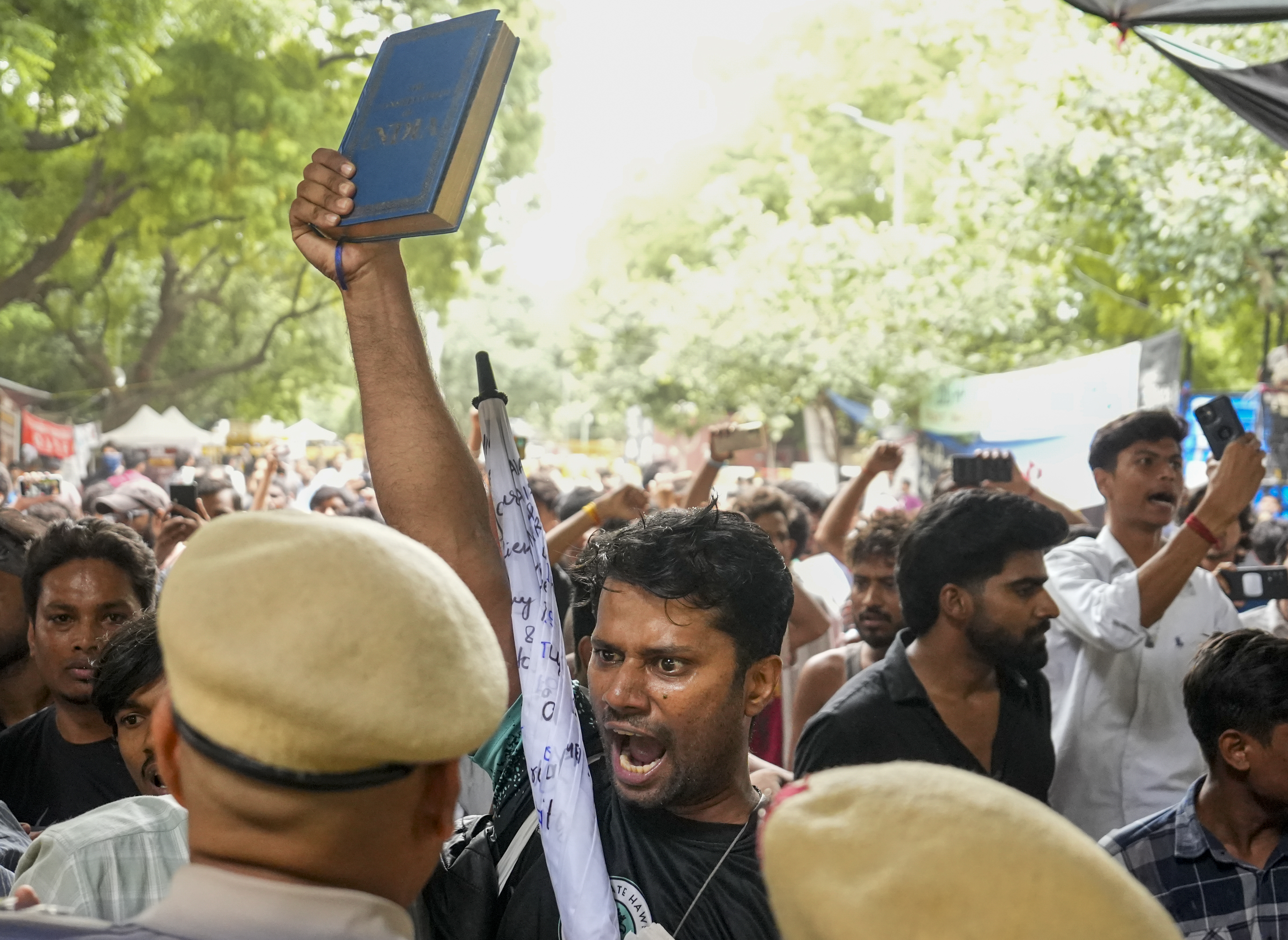 Security personnel detain supporters of the Cockroach Janata Party (CJP) as they raise slogans in New Delhi, on Saturday.