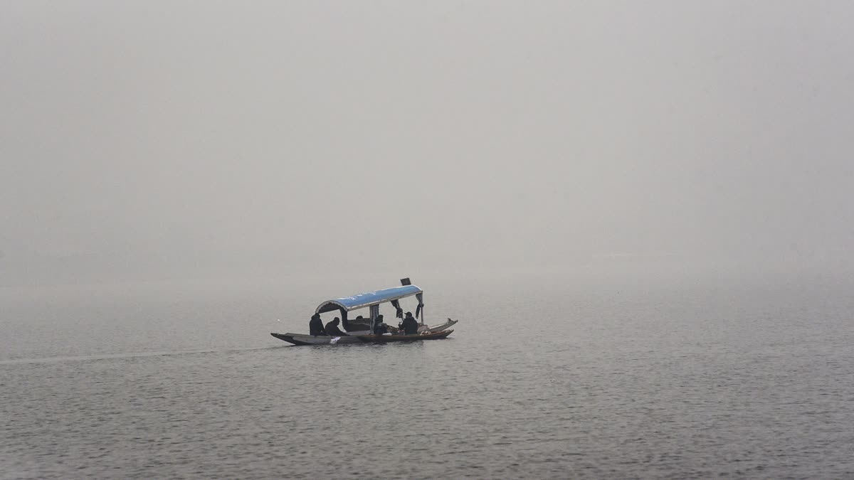 Tourists enjoy a Shikara ride on a cold foggy winter day in the Dal Lake in Srinagar