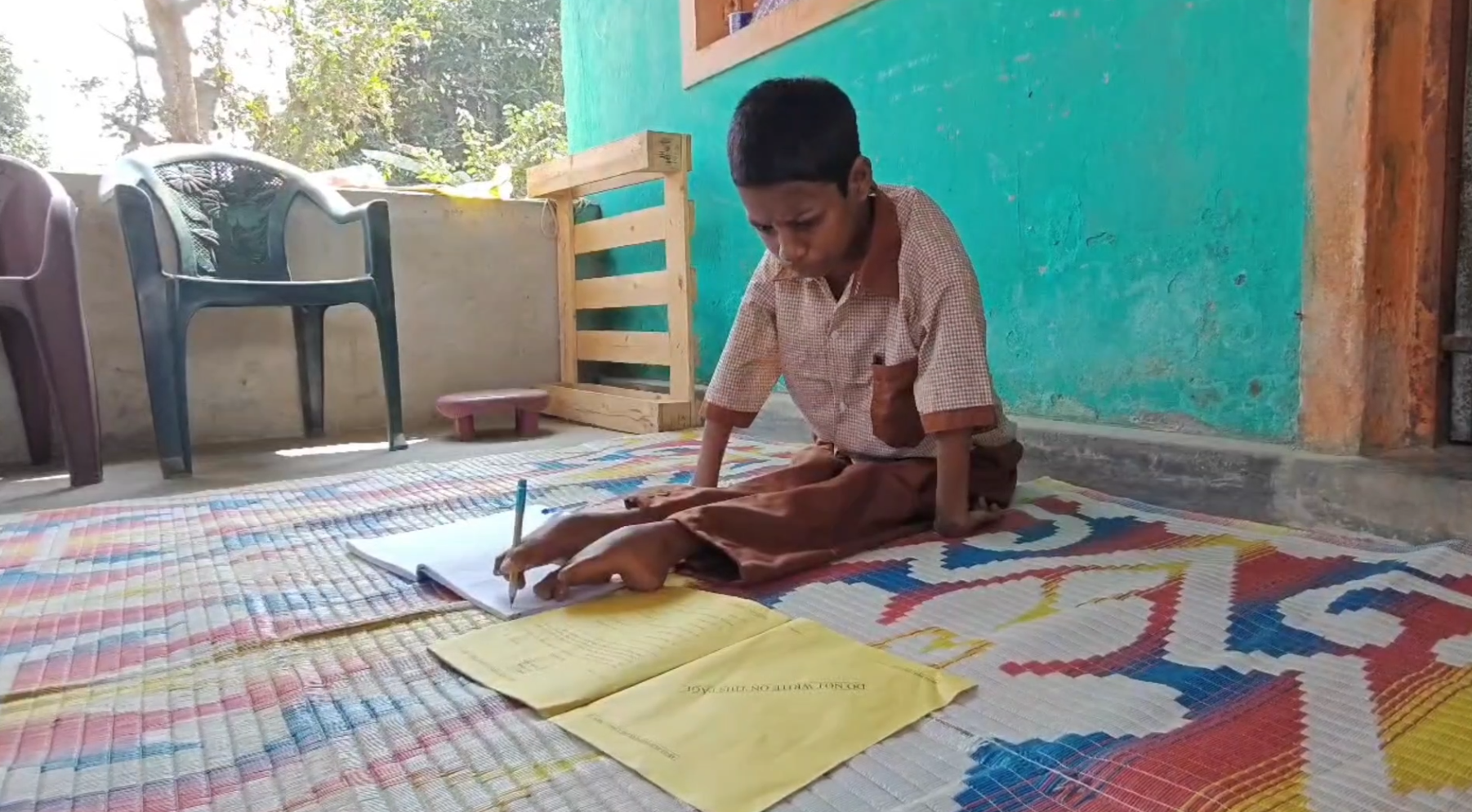 Lakshmi Khemudu is writing by foot.