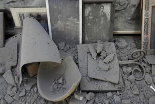 Dust covers framed family photos and personal objects at the site of a direct hit from an Iranian missile strike in Ramat Gan, Israel on Thursday