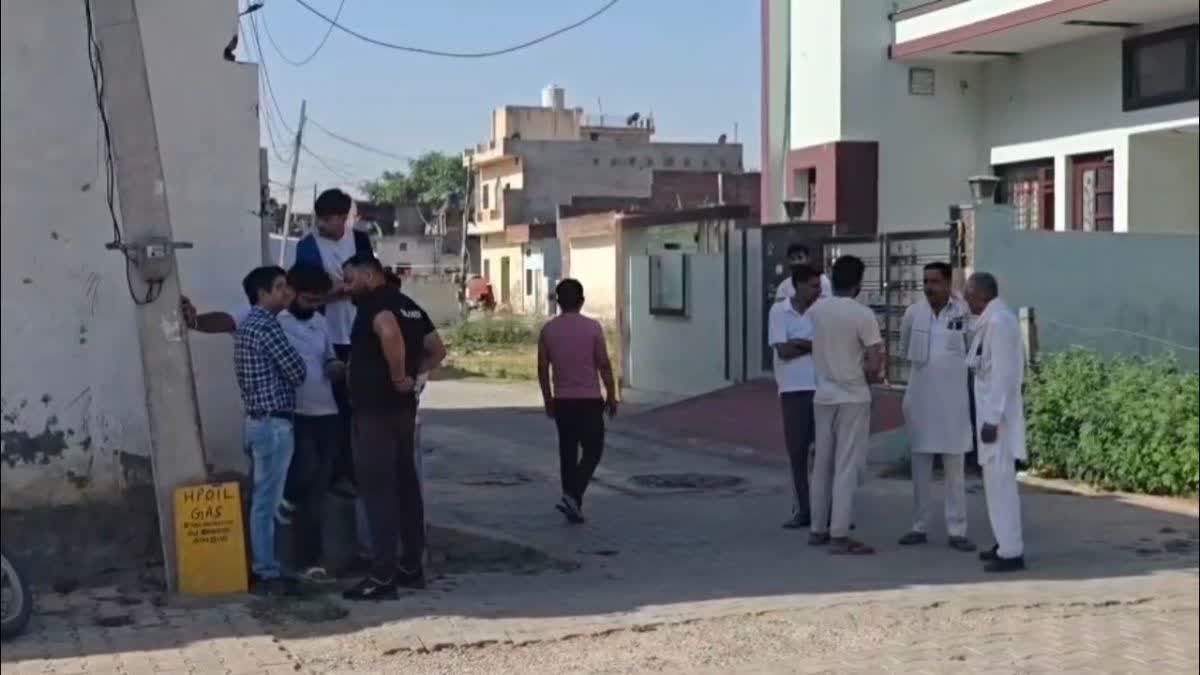 Locals gather outside the house where a couple and their toddler daughter die by suspected suicide in Kurukshetra