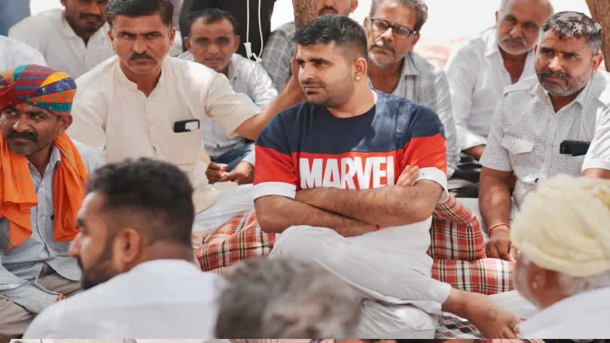 MLA Bhati sits on a sit-in protest with villagers.