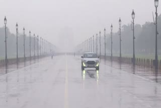 A vehicle makes its way through a rain-slicked road at Kartavya Path amid rainfall, in New Delhi on Wednesday.