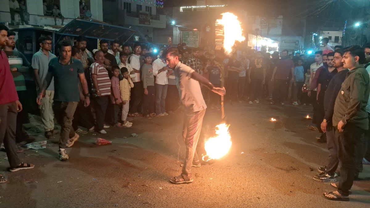 A man twirls a fire staff on eve of Diwali in Bikaner, Rajasthan