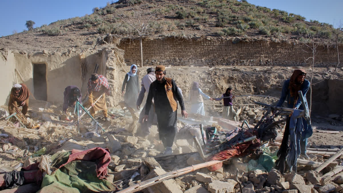 Afghan men search through the rubble at the site of an overnight attack on a home that, according to an Afghan government spokesman, was carried out by Pakistan, in the Gurbaz district of Khost province, Afghanistan, Tuesday, Nov. 25, 2025.