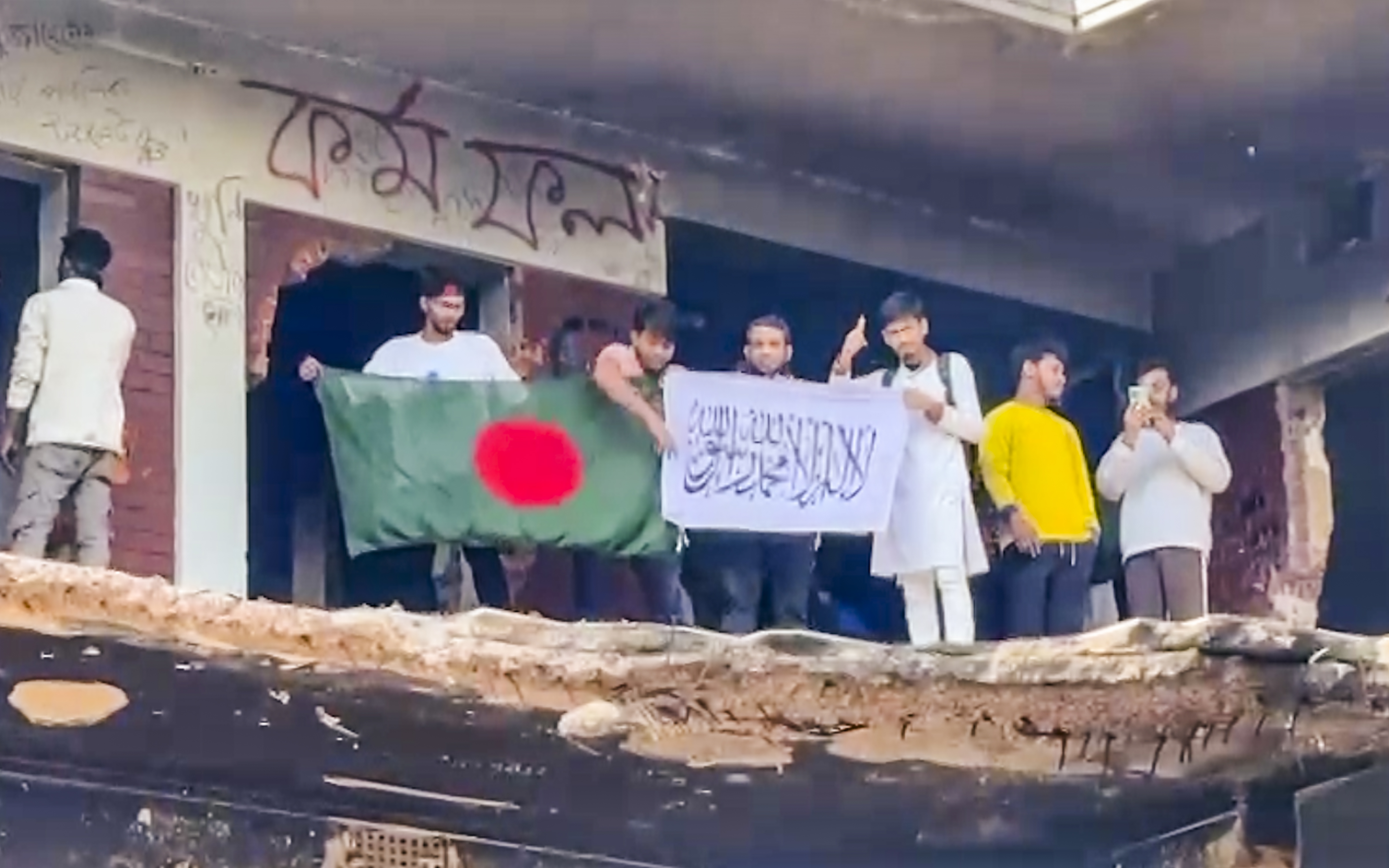 People stand inside damaged premises of Bangladesh's founding father Sheikh Mujibur Rahman's home after it was vandalised by protesters following the death of Sharif Osman Hadi, at 32 Dhanmandi, in Dhaka, Friday, Dec. 19, 2025.