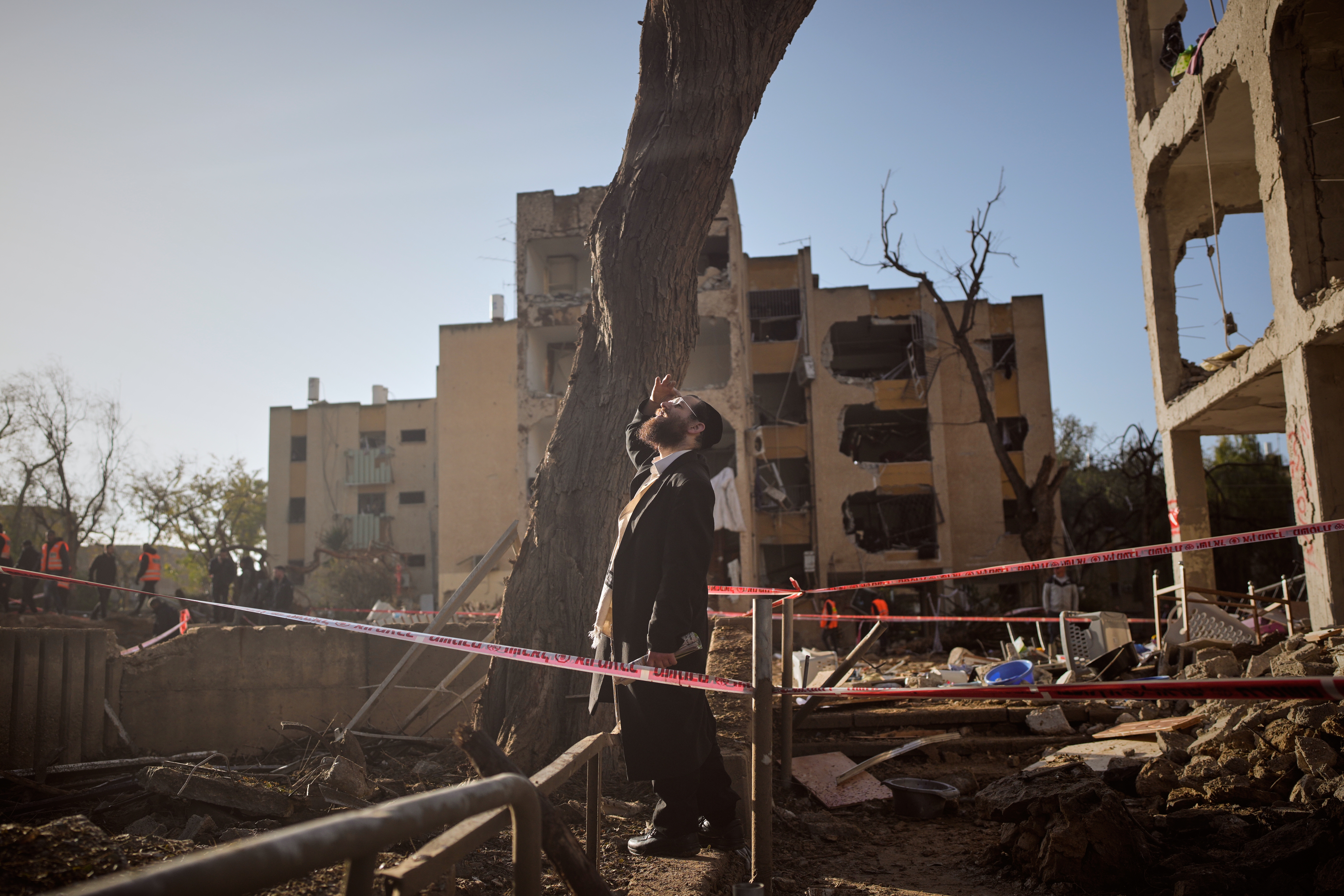A man looks at residential buildings damaged by an Iranian missile attack in Arad, southern Israel, on Sunday, March 22, 2026.