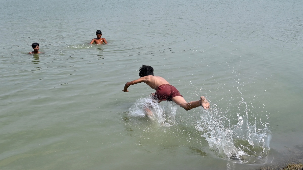 Children bathing in water to get relief from the heat.