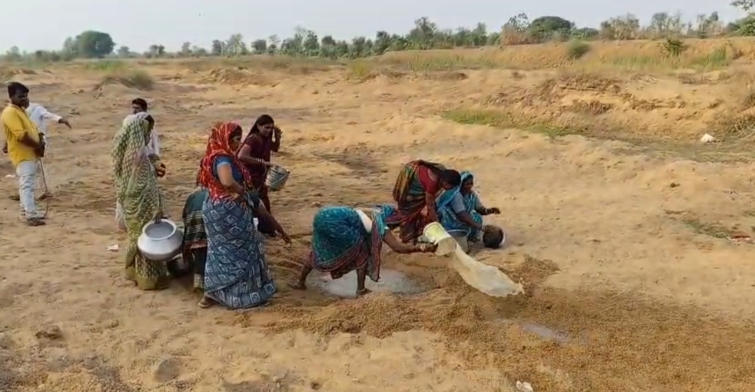 Women drawing water from a pit