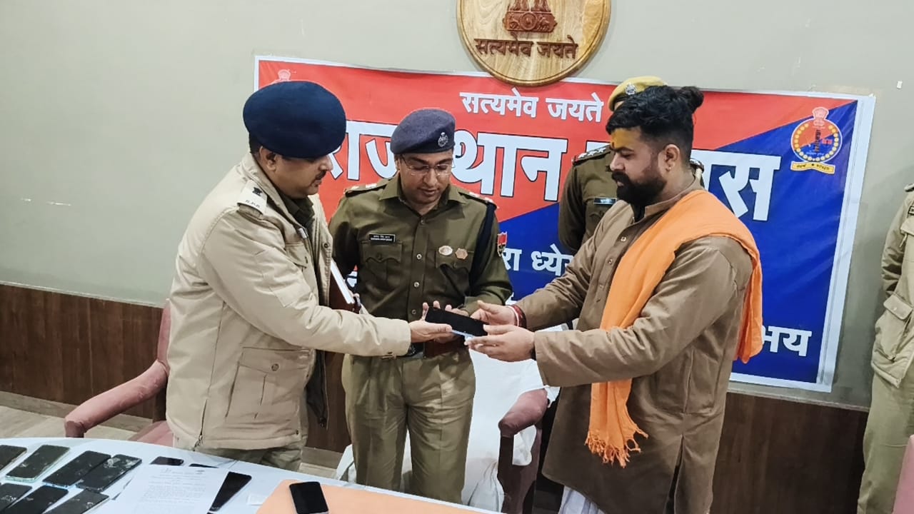 Police officer returning the mobile phone to the owner