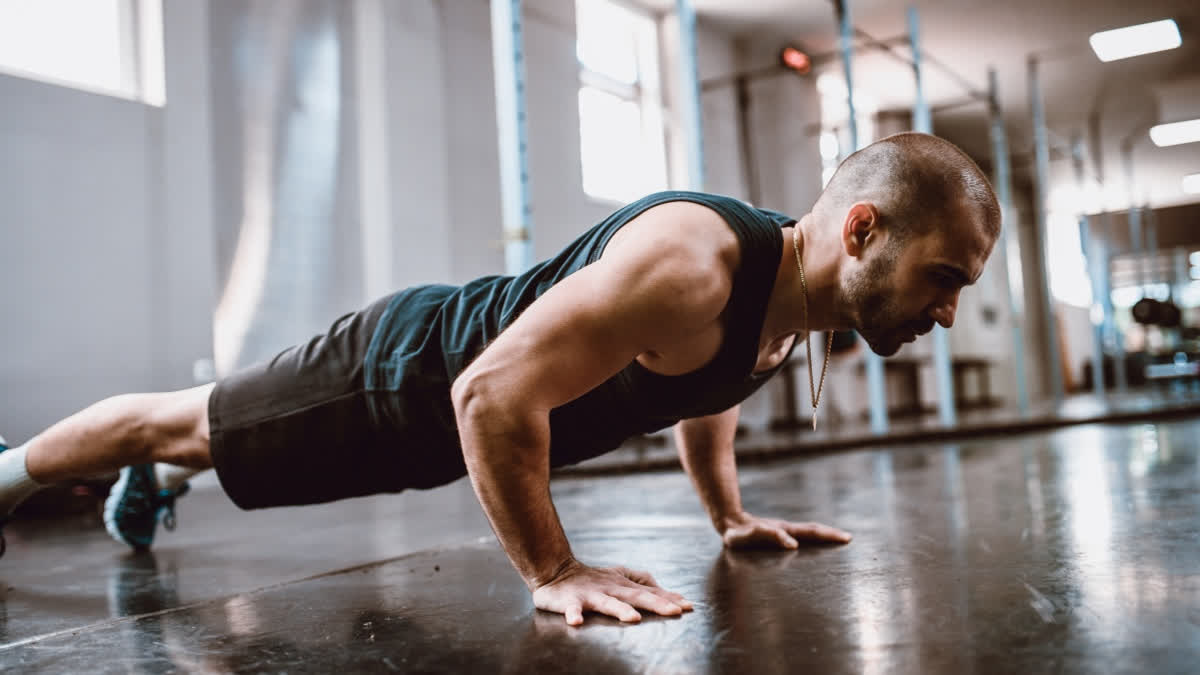 Weak Arms And Shoulders? Here's How To Get Stronger In Your Upper Body Without Using Any Weights To Work Out Man doing push ups in the gym