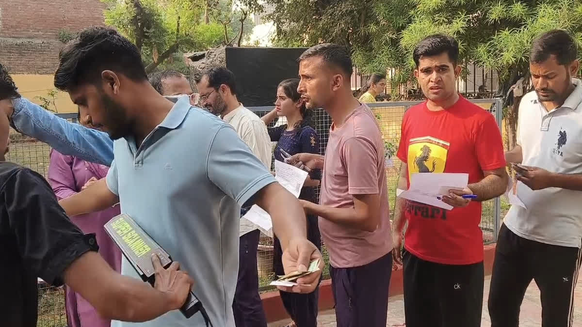Candidates undergoing frisking at gate for exam