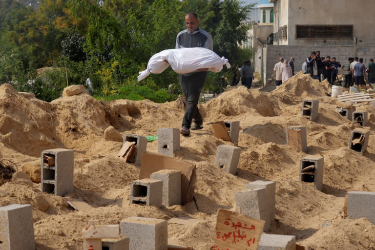 Day 17 of Israel-Palestine war: Gaza death toll crosses 5,000 including over 2,000 children; Israeli airstrikes continue ahead of ground offensive Palestinians bury the bodies of their relatives killed in the Israeli bombardment of the Gaza Strip, at a cemetery in Deir Al-Balah, Gaza, Monday, Oct. 23, 2023. (AP Photo/Hatem Moussa)