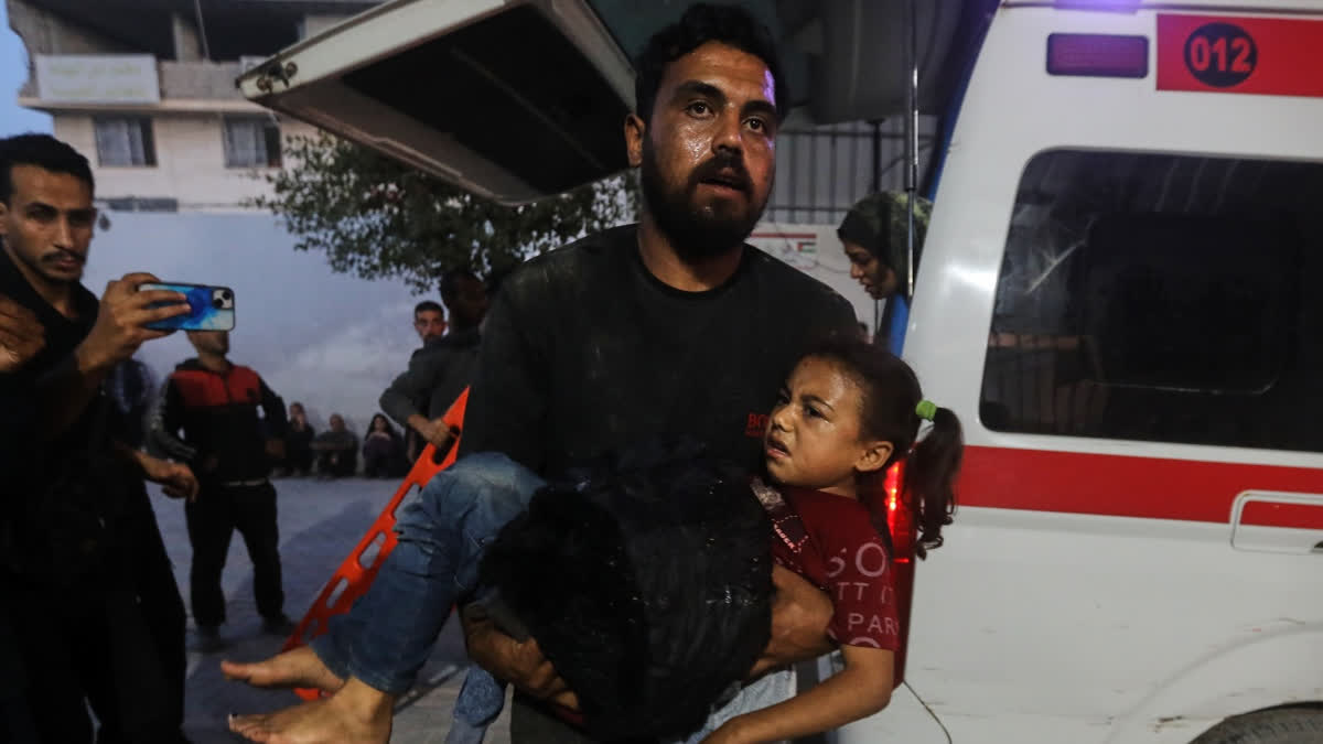 Gaza Civil Defence Says 21 Killed In Israeli Strikes A Palestinian man carries a wounded girl into al-Shifa Hospital following Israeli strikes on the Gaza Strip, Saturday, Nov. 22, 2025.