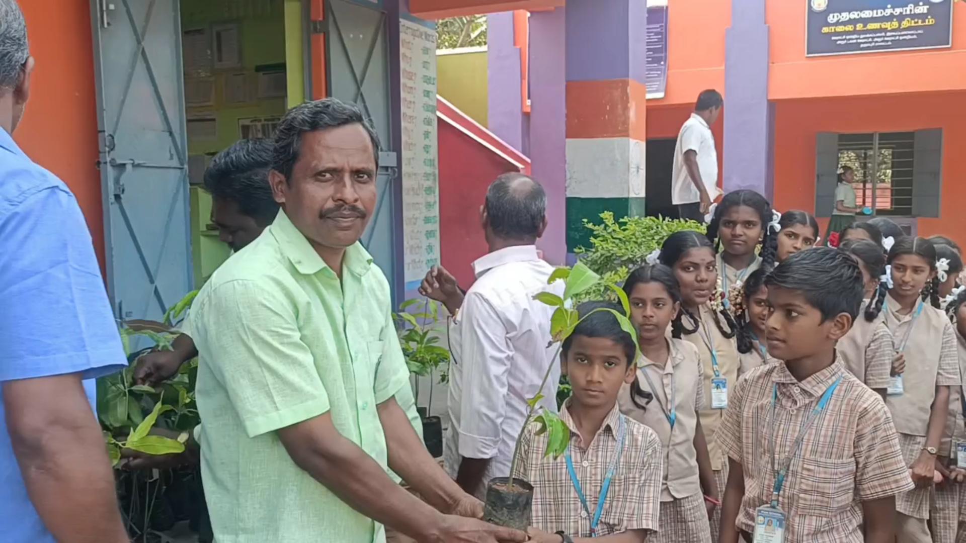 பள்ளி மாணவர்களுக்கு மரக்கன்றுகளை விநியோகிக்கும் இயற்கை காப்போம் அமைப்பில் உள்ள அரசு பள்ளி ஆசிரியர் தாமோதரன்