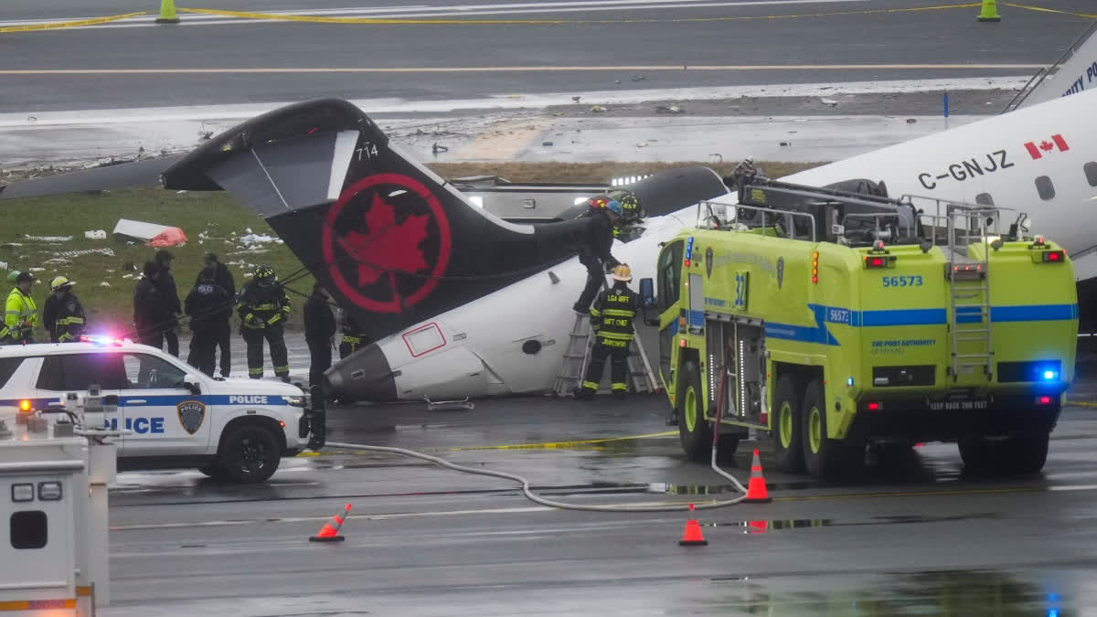 Officials investigate the site, Monday, March 23, 2026, where an Air Canada jet came to rest after colliding with a Port Authority firetruck at LaGuardia Airport, shortly after landing Sunday night in New York.