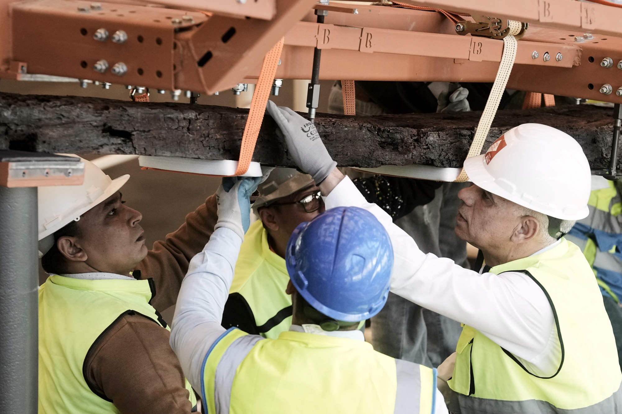 Archeologists carry an ancient wooden block as they reassemble the second solar boat of King Khufu, at the Grand Egyptian Museum in Giza, Egypt, Tuesday, Dec. 23, 2025.