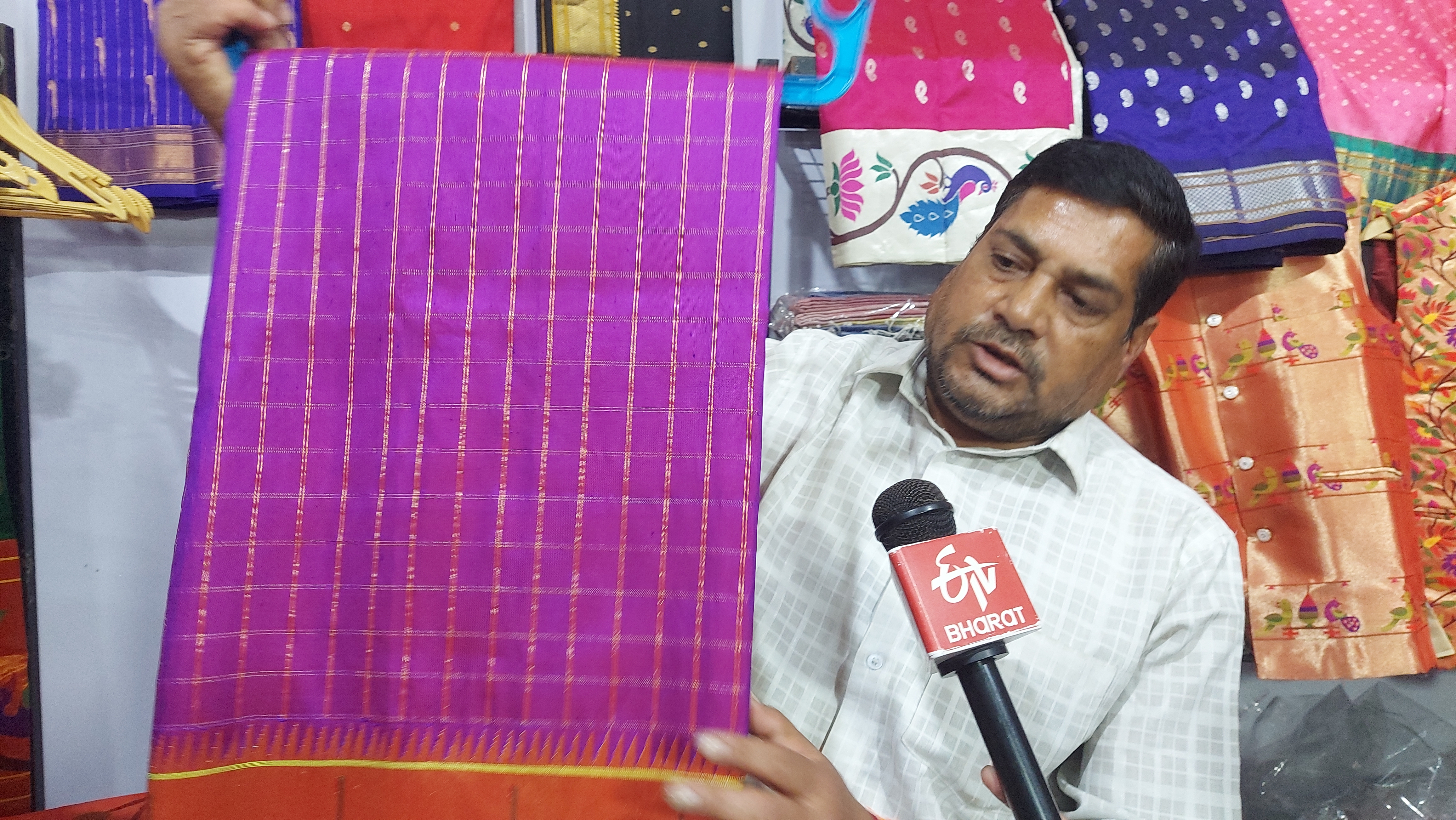 The shopkeeper giving information about the Paithani saree