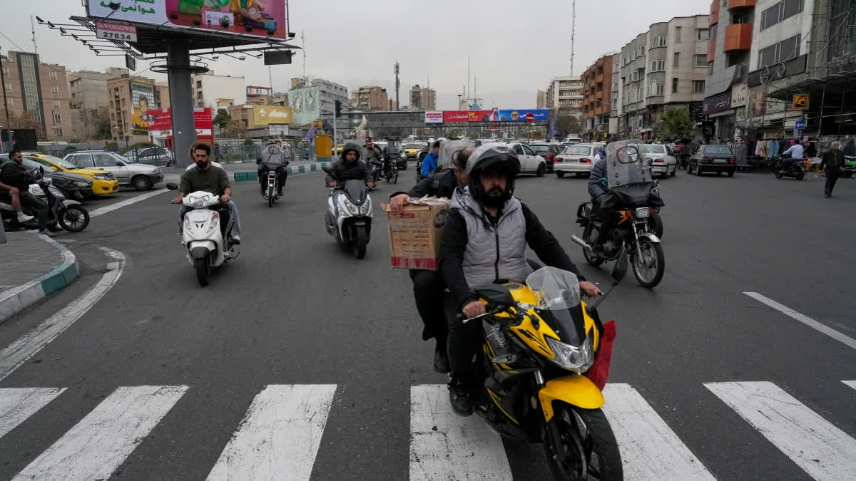 People drive their motorbikes in a square in downtown Tehran, Iran, Tuesday, Feb. 24, 2026.