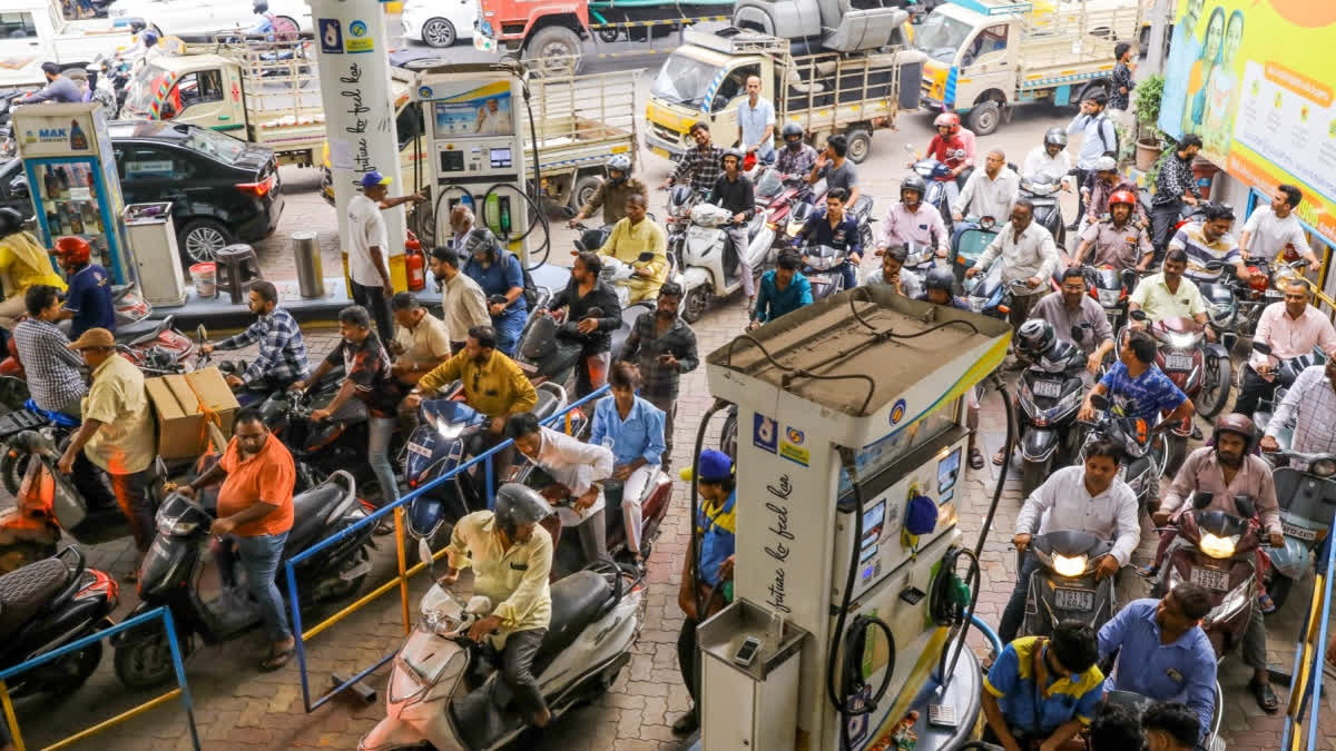 People queue up at a petrol bunk in large numbers amid rumours of fuel shortage in the wake of the West Asia conflict, in Hyderabad.