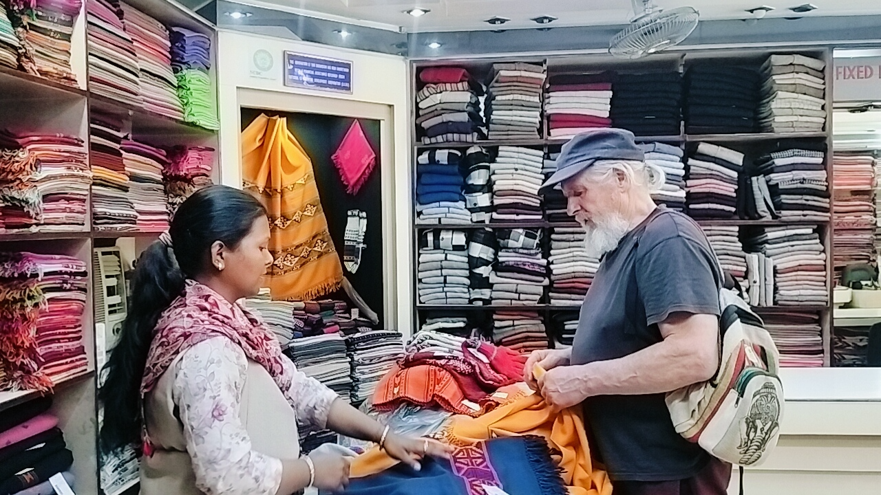 A customer inspecting shawls