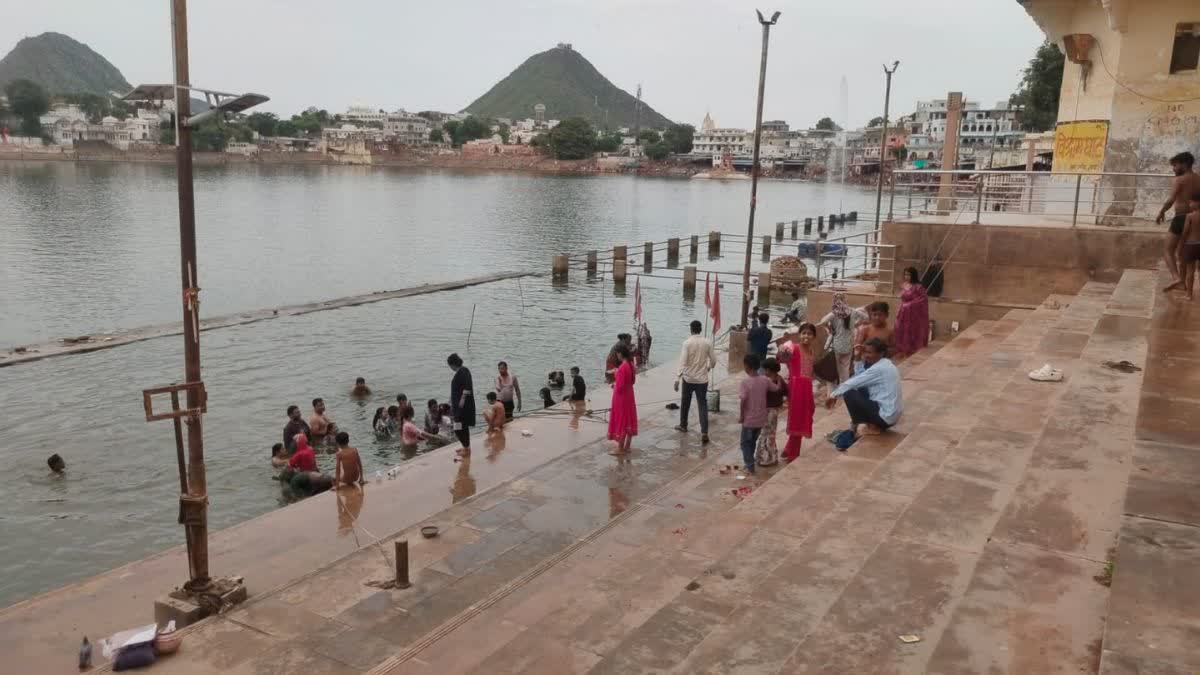पुष्कर सरोवर में आस्था की डुबकी लगाते हुए लोग