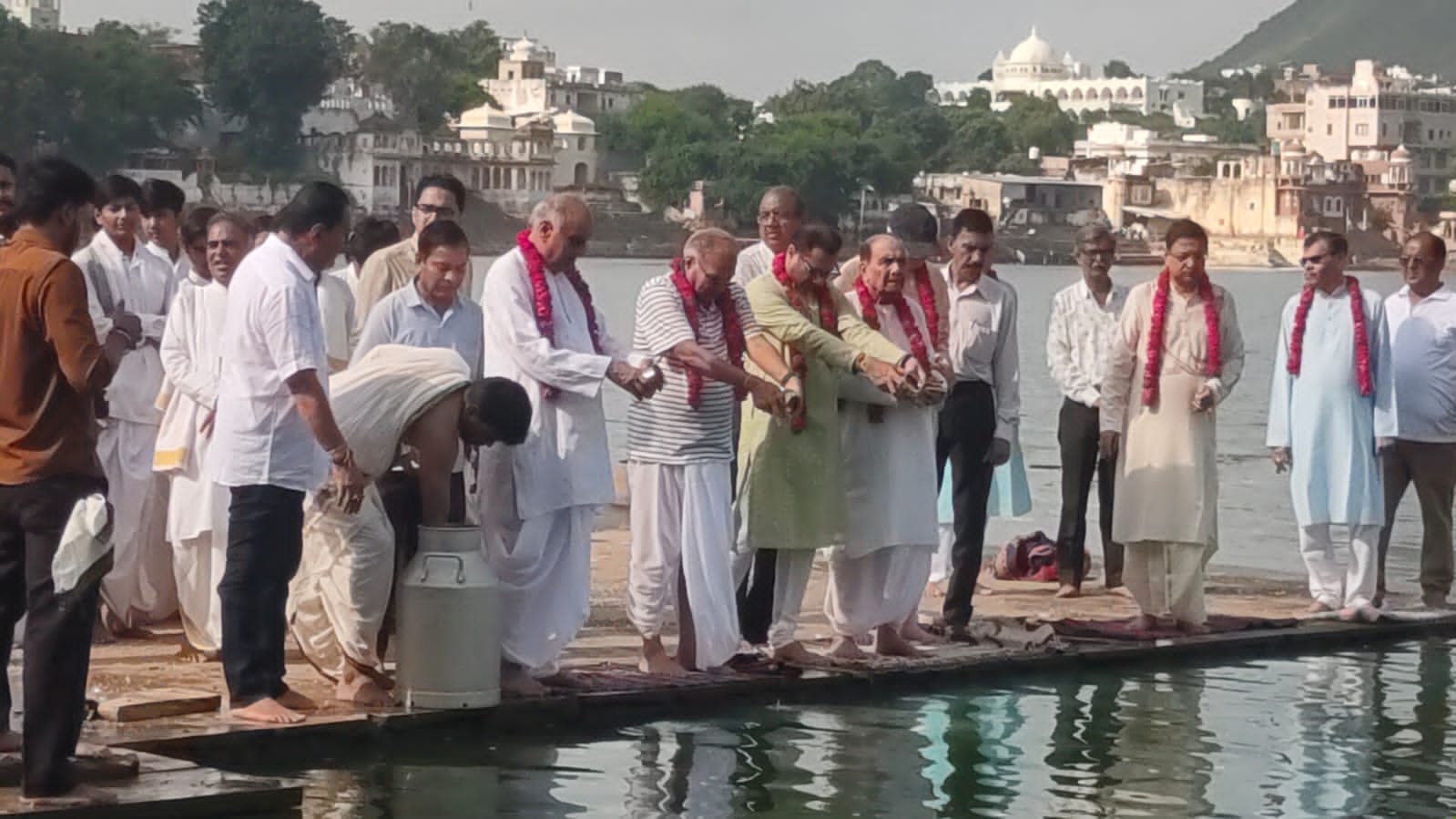 Trustees and temple priests performing worship rituals at the lake