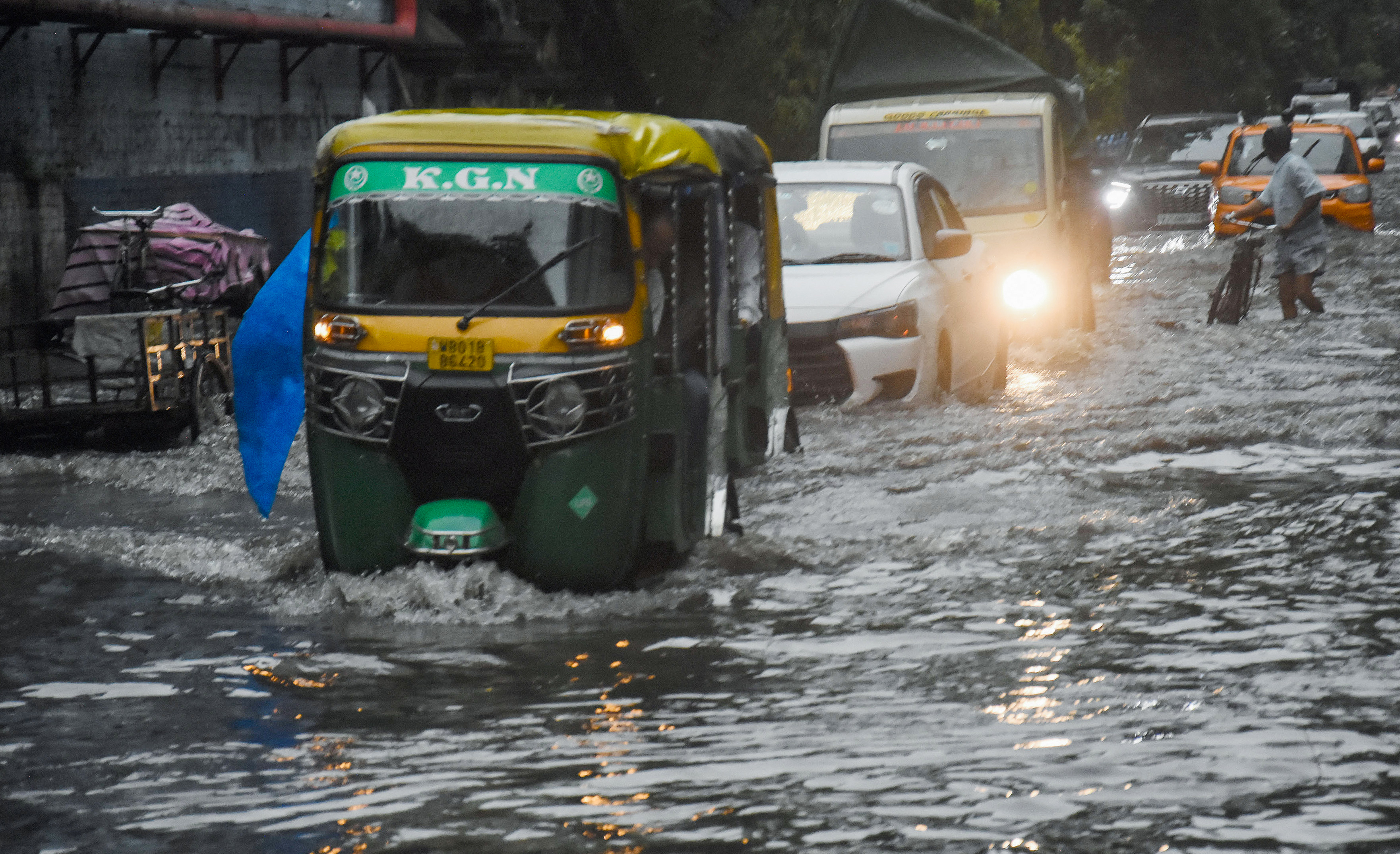 Commuters wade through a waterlogged road in Kolkata on Thursday.