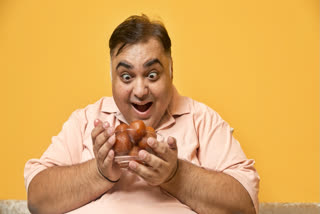 Man looking at a plate of gulab jamuns