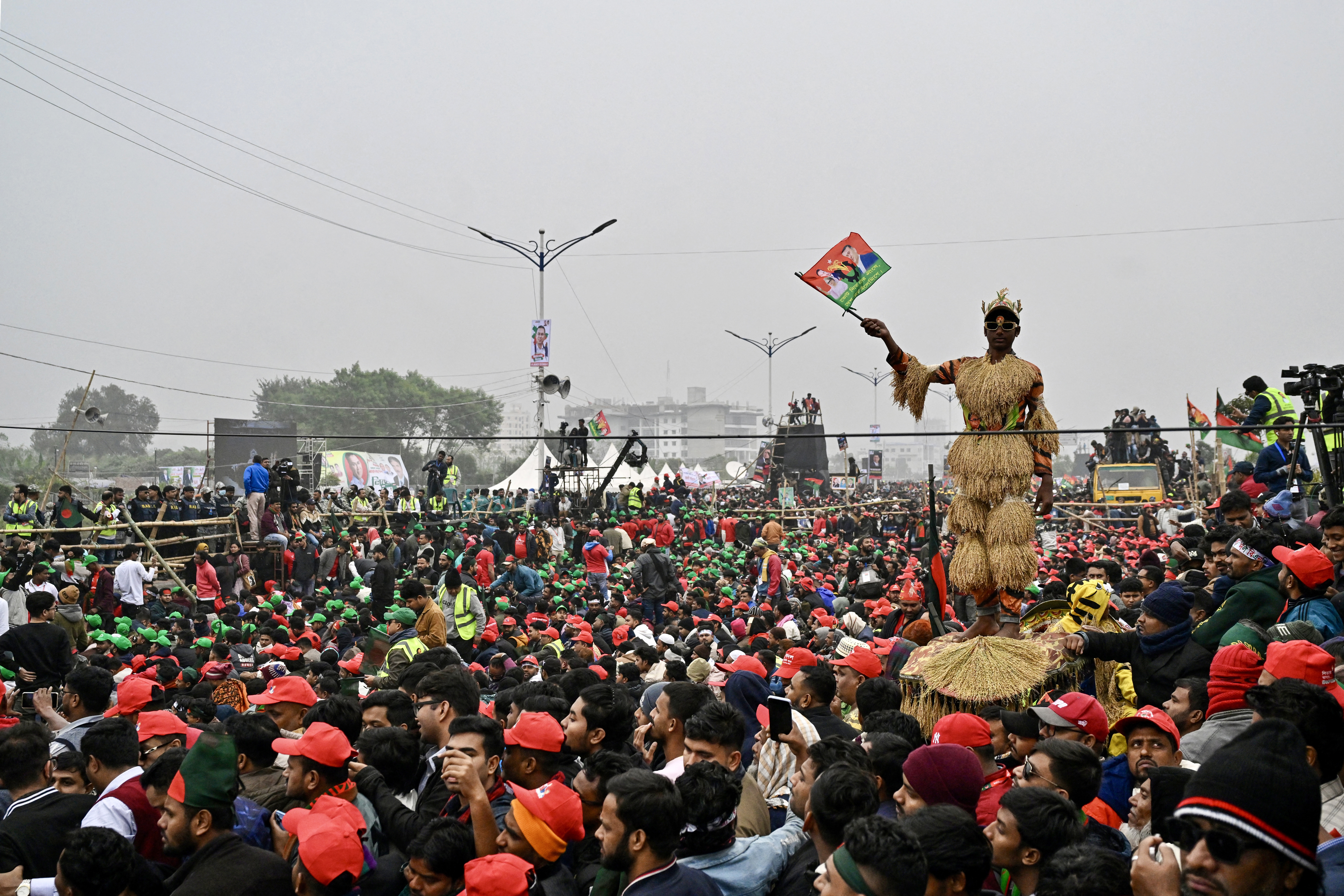 A supporter of Tarique Rahman, son of former prime minister Khaleda Zia and Bangladesh Nationalist Party (BNP)'s acting chairman waves the party flag with their portraits during a rally after Rahman's arrival in Dhaka on December 25, 2025.