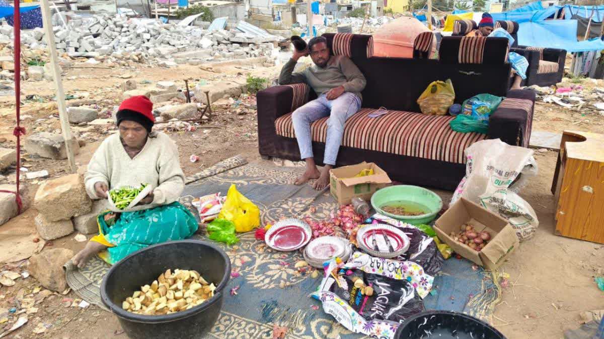 A family prepares food in a temporary tent in Kogilu.