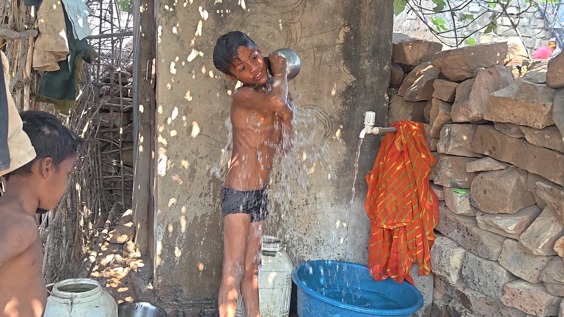 सप्लाई के पानी से स्नान करते बच्चे.