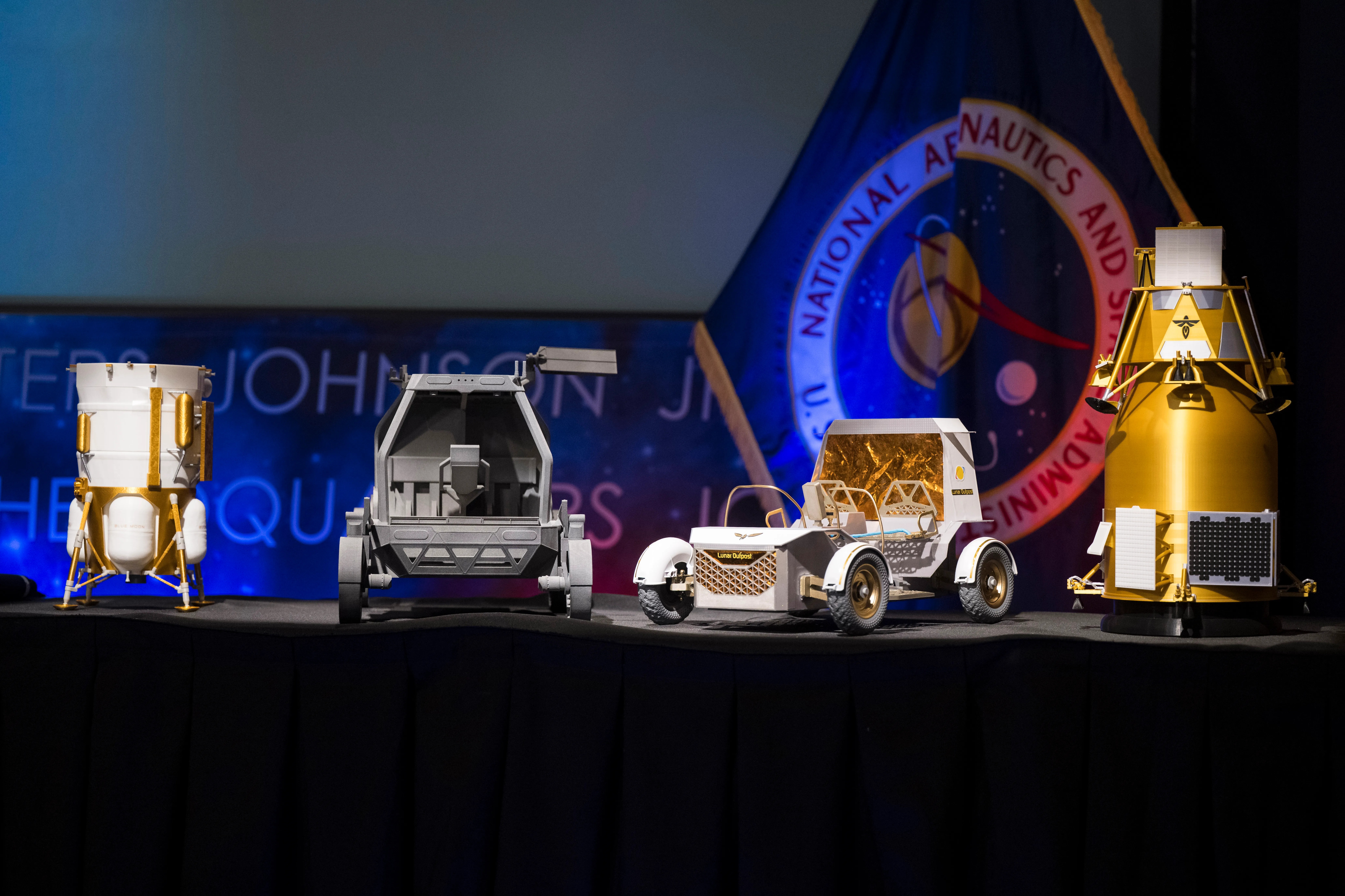 (From left to right) Models of the Blue Origin Mk1 Lunar Lander, Astrolab Crewed Lunar Rover, Lunar Outpost Pegasus Rover, and Firefly Elytra Dark Orbiter.