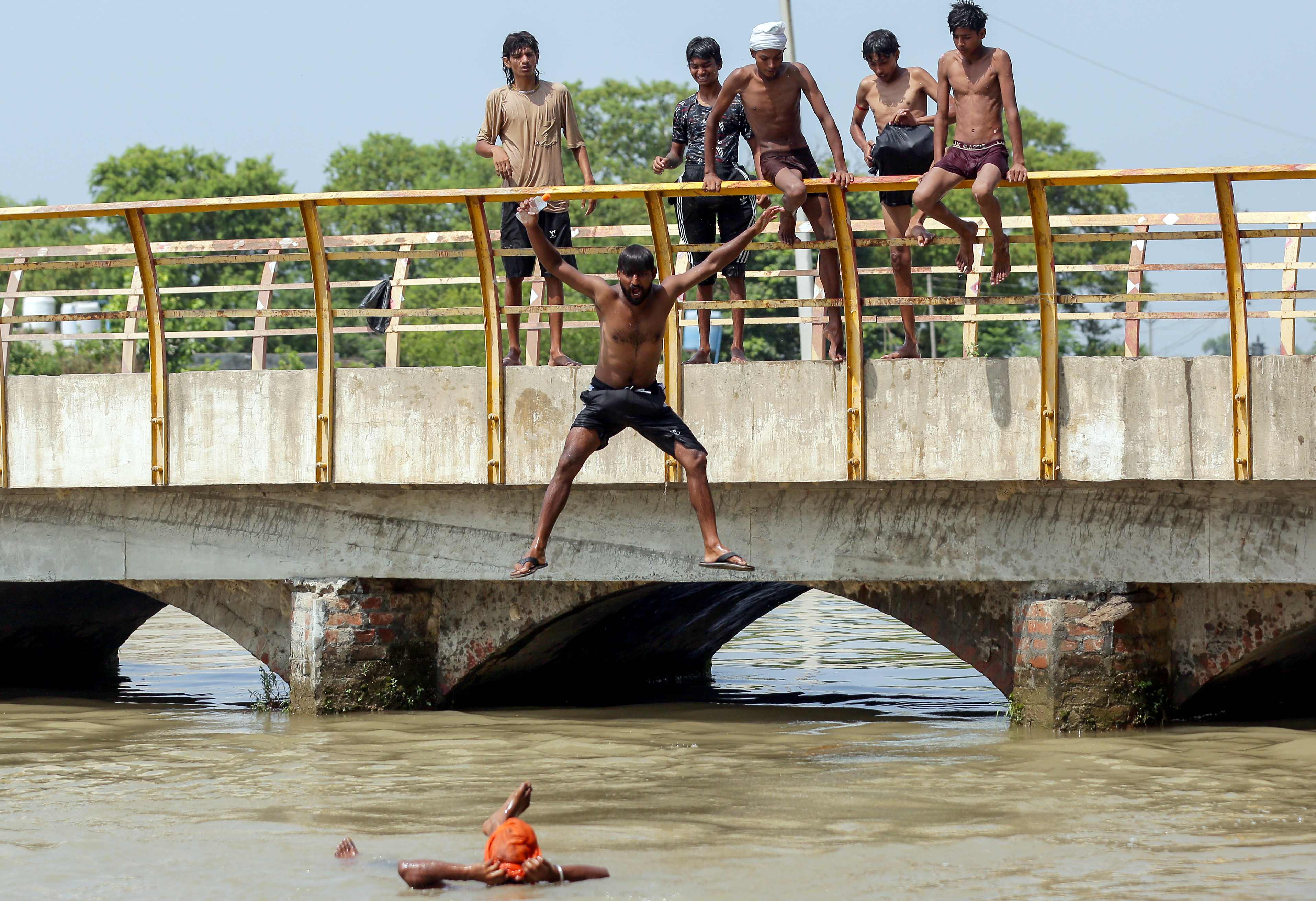 गर्मी से राहत पाने के लिए नदी में नहाते बच्चे