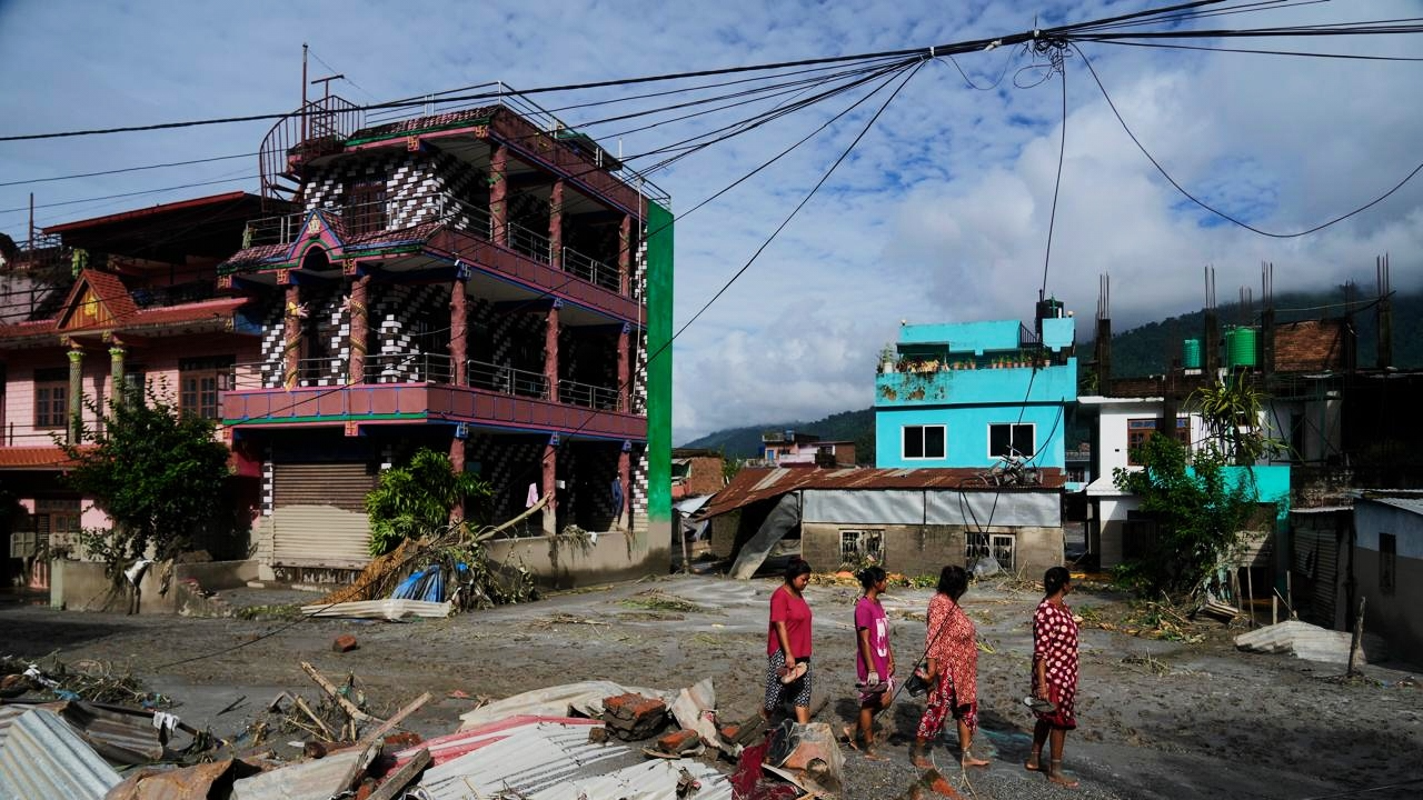 People walk past damage in the aftermath of flash floods in Devighat in the Nuwakot district in Nepal, Thursday, Aug 27, 2026.