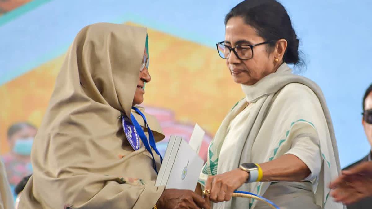 \Mamata Banerjee with a beneficiary during a public meeting in Singur on Wednesday.