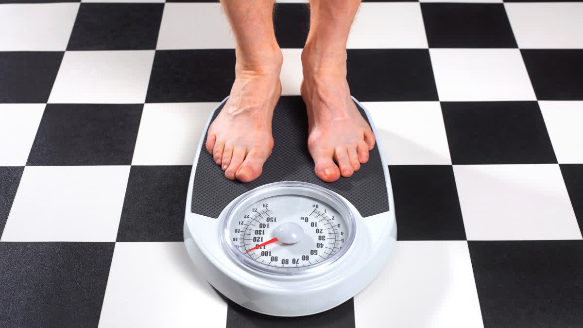 When Is Surgery Better Than Dieting? Surgeon Explains The Science Behind Bariatric Surgery Man standing on a weighing scale