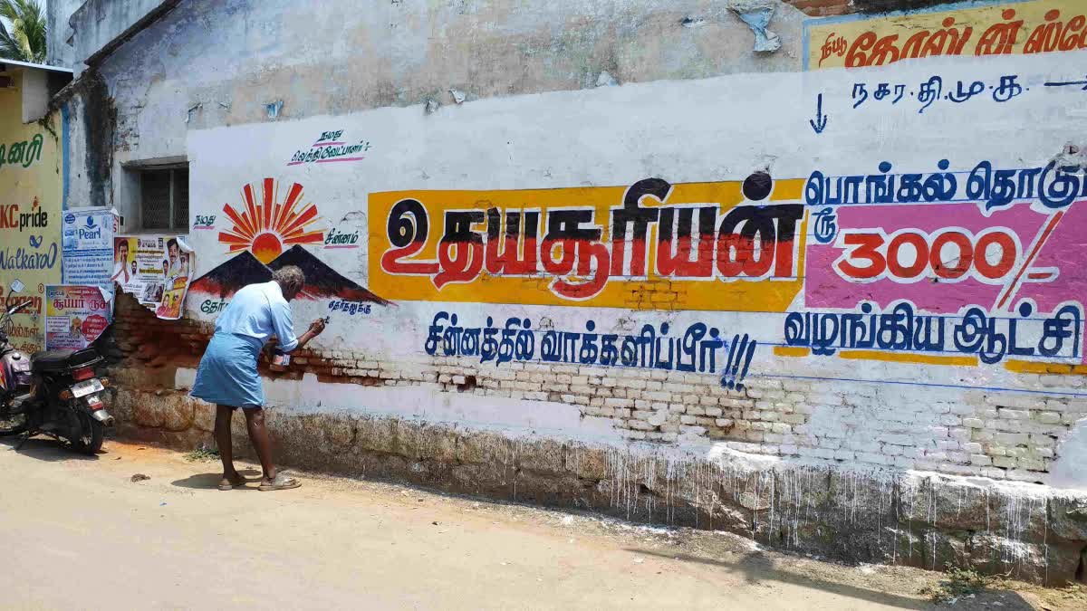 சுவரில் கட்சி சின்னம் வரையும் ஓவியர்