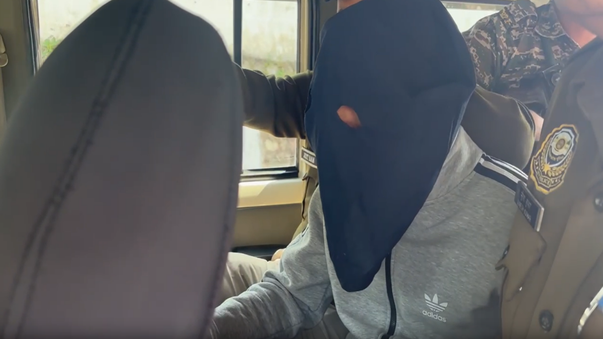 मुख्य शूटर को गाड़ी में ले जाती पुलिस